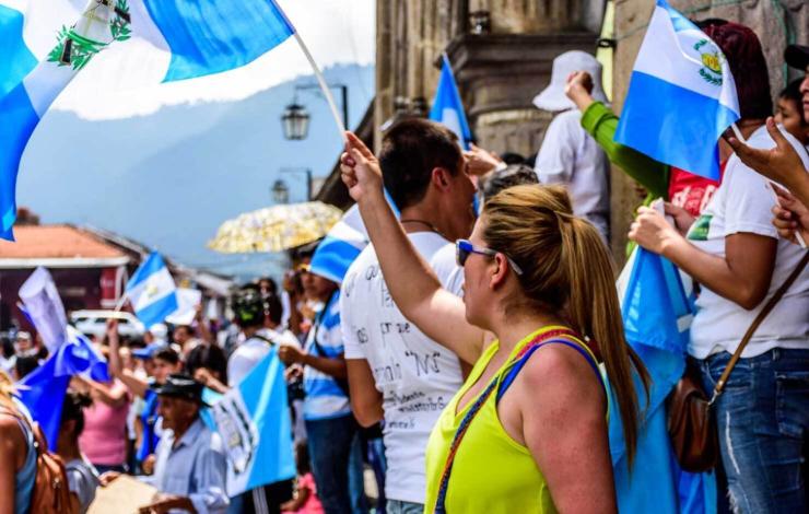 crowd of people waving Guatemalan flags